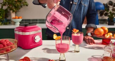 Hibiscus blender pouring hibiscus colored smoothie into glasses